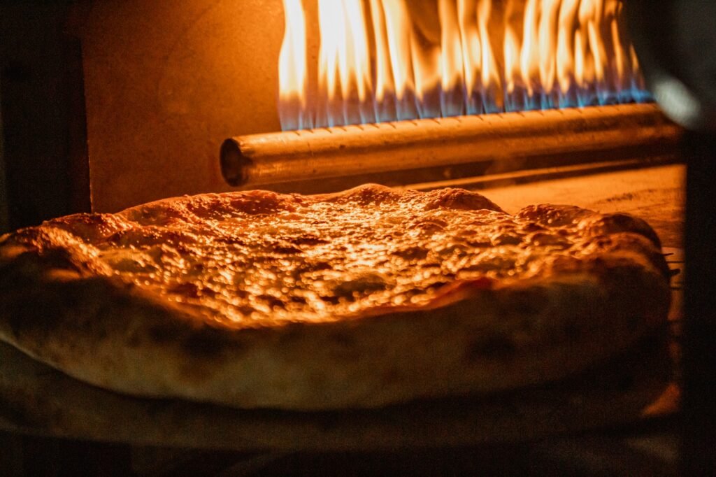 Pizza estilo napolitana assando em forno a gás de alta temperatura