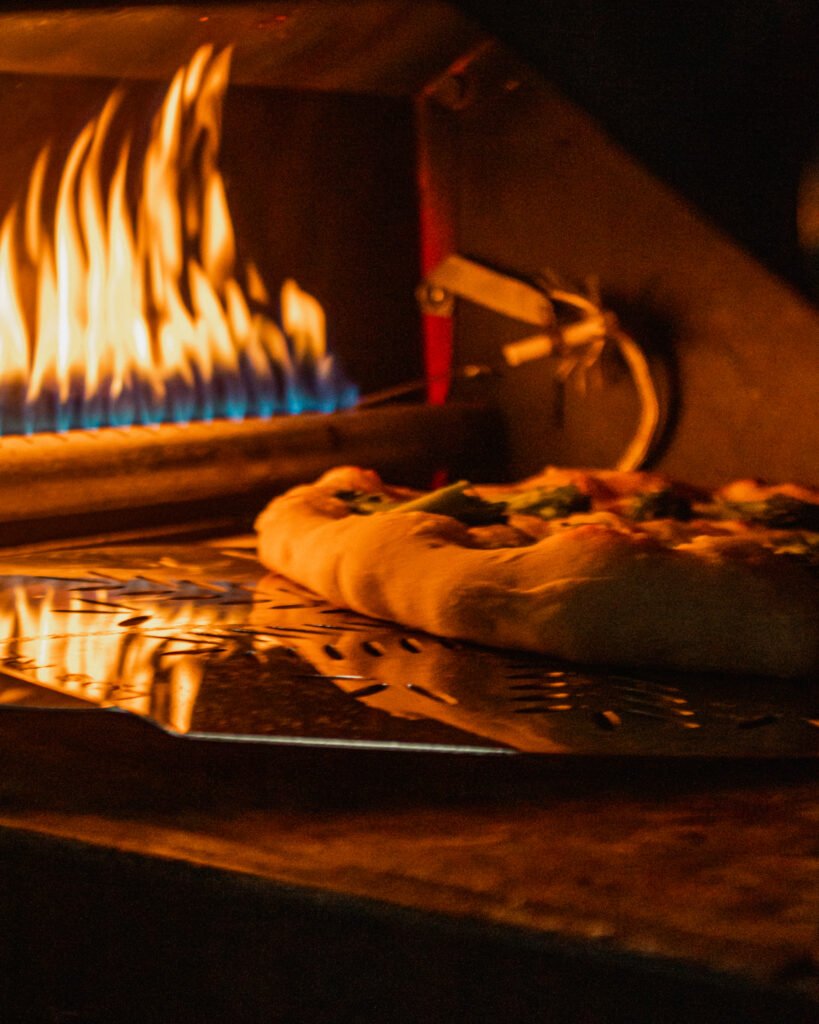 Pizza estilo napolitana assando em forno a gás de alta temperatura